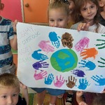 Dzieci trzymające plakat z ziemią i odbitymi dłońmi.jpg