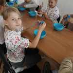 Dzieci siedzące przy stole i robiące slime.jpg