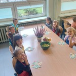 Dzieci siedzą przy stoliku na którym stoi sałatka owocowa.jpg