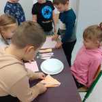 Dzieci z klasy pierwszej układają zastawę stołową - talerze, sztućce, serwetki.jpg.jpg