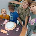 Dzieci z klasy pierwszej układają zastawę stołową - talerze, sztućce, serwetki.jpg.jpg
